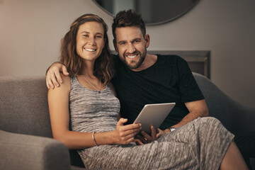 Poster - Taking our quality time to the sofa. Portrait of a young couple using a digital tablet together while relaxing on the sofa at home.