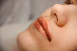 © NASTYA PALEHINA - intermediate result beauty procedure. closeup permanent lip tattoo. side view. beauty concept, free space
