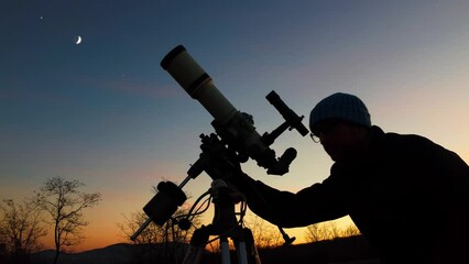 Wall Mural - silhouette of a man, telescope and countryside under evening skies.