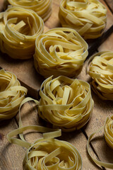 Wall Mural - Pasta nests on a wooden background. Shape of pasta. traditional cooking