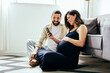 © kleberpicui - Pregnancy and technology concept. Pregnant woman and her husband spending time together using smartphone.