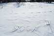 Yoga letters are written on the snow in winter in the cold season. Silence in the text of yogic symbols, a sunny day.