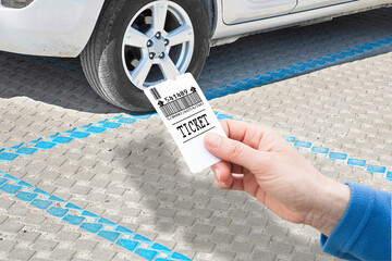 Poster - Female hand holds a parking ticket - parking payment concept with parked car