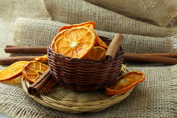 Wall Mural - dry orange citrus fruits slice with cinnamon stick for snack,decoration,food,health,christmas related concept on jute fabric background 