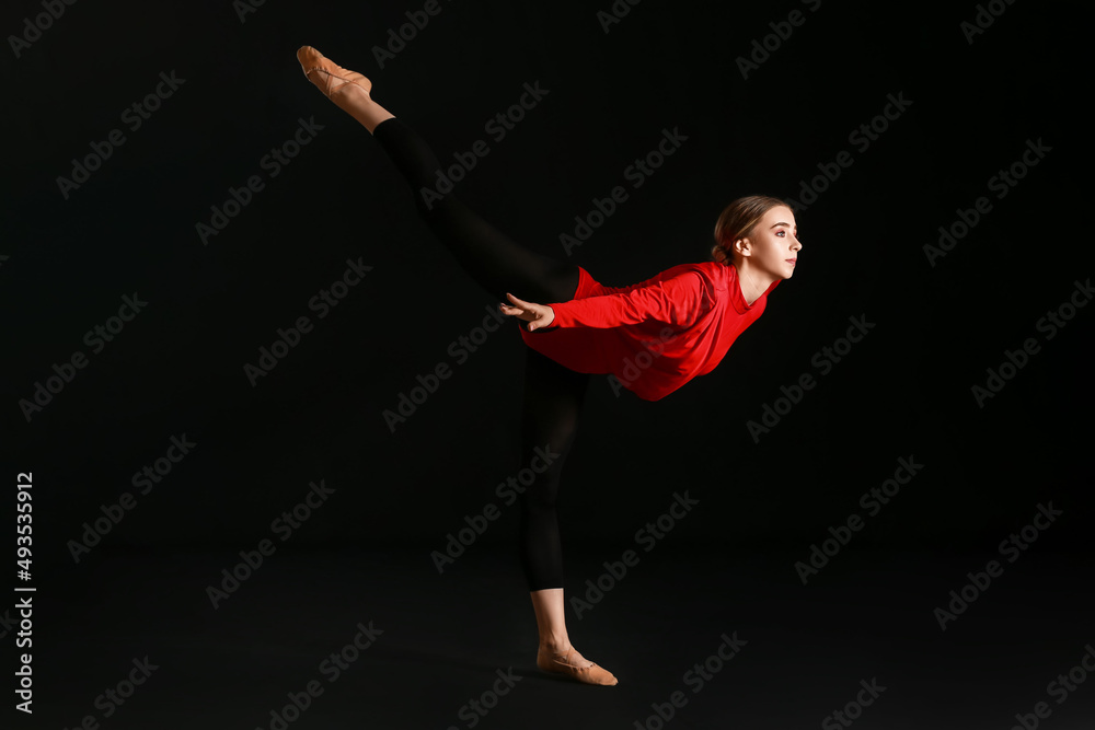 Beautiful young woman doing gymnastics on black background