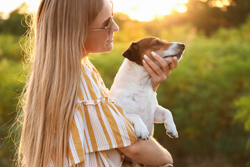 Canvas Print - Young woman holding cute Jack Russel dog in park