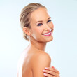 © Yuri A/peopleimages.com - Simply radiant. Studio shot of a beautiful young woman with perfect skin against a blue background.