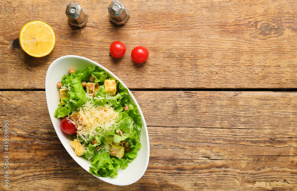 Bowl with tasty vegan Caesar salad on wooden background