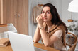 © Pixel-Shot - Worried young woman with laptop sitting at table