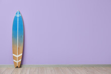 Blue Surfboard Near Lilac Wall