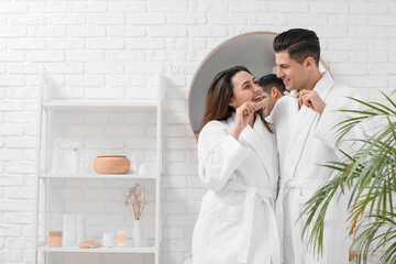 Young couple brushing teeth with activated charcoal tooth paste in bathroom