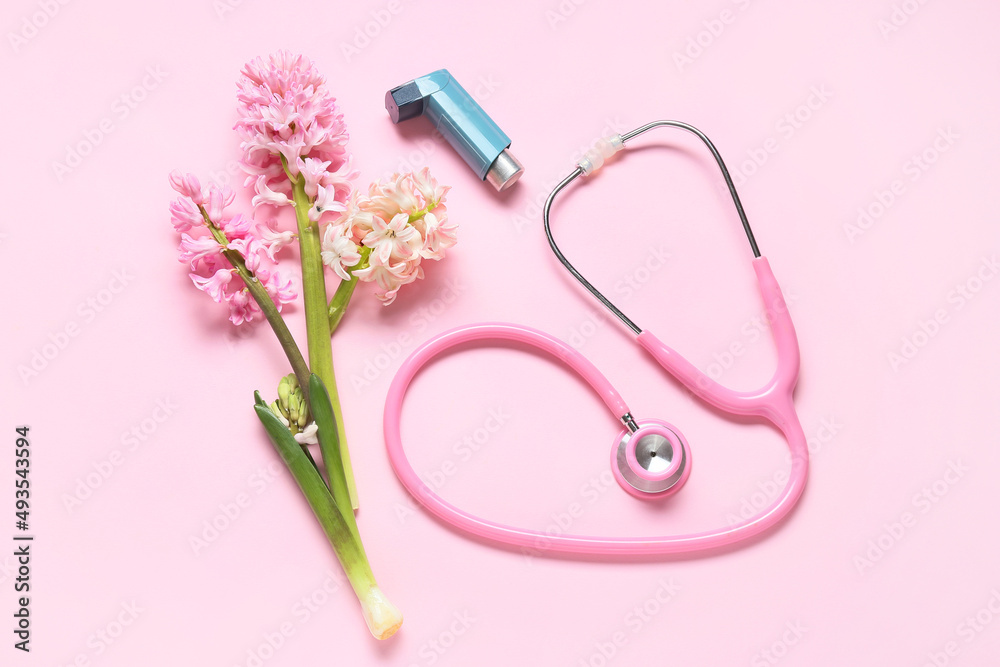 Composition with inhaler, stethoscope and hyacinth flowers on pink background
