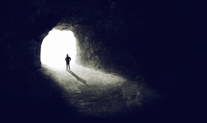 Wall Mural - Finding the light. A shot of someone finding an exit from a dark tunnel.