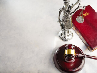 Wall Mural - Judge's gavel, sculpture of the goddess of justice - Themis and the Bible on a white background. Low angle view. Justice, symbols of law, Constitution, independence.