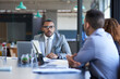 © Adene S/peopleimages.com - Gathered around the boardroom table. Cropped shot of a group of young businesspeople sitting in the boardroom during a meeting.