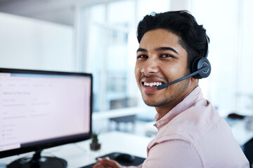 Im here to assist - just give me a call. Portrait of a young call centre agent working on a computer in an office.
