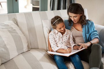 Poster - Learning with love. Shot of a young woman helping her adorable daughter with her homework at home.