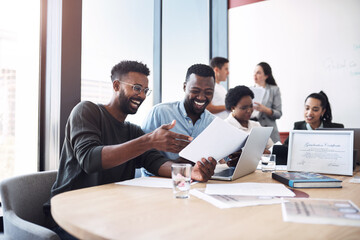 Sticker - Look at how our profits have skyrocketed. Shot of two businessmen going through paperwork together in an office with their colleagues in the background.