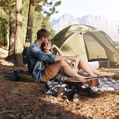 Wall Mural - Into the woods. Shot of an affectionate young couple sitting at their campsite.