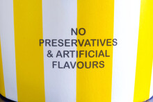The Words 'No Preservative And Artificial Flavours' Printed On The Side Of An Ice Cream Container Tub, Indicating The Food Or Product Is Made With Natural Or Chemical Free Ingredients. Closeup View.