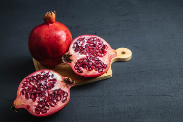 Pomegranate fruit sliced ​​on a black background