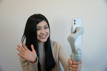 スマホで動画をとる日本人女性　自撮り　youtuber Vlog　ライブ配信　バストショット
