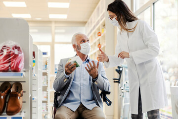 Wall Mural - An old disabled man asking for pharmacist opinion about medicine.