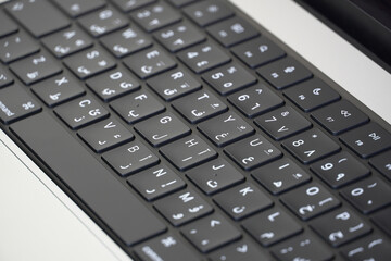 Close up of laptop keyboard with two languages Arabic and English, arabic letters