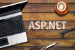 Asp.net  programming language. Word asp.net laptop, glasses and coffee on wooden table