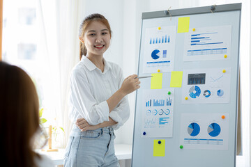 Atmosphere in the office of a startup company, two female employees are discussing, brainstorming ideas to work on summaries and marketing plans to increase sales and prepare reports to managers.