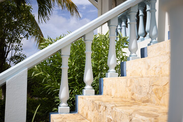 Porch stairs on the house entrance with decorative blue columns.