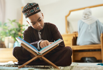 Poster - Children more than ever, need opportunities. Shot of a young muslim boy reading in the lounge at home.