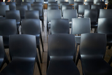 Many Black Chairs in a Row. evocative series of chairs. rows of chairs, empty seats - chair row