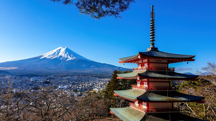 View on Chureito Pagoda and mountain of the mountains Mt Fuji, Japan, captured on a clear, sunny day in winter. Top of the volcano covered with snow. Trees aren't blossoming yet. Postcard from Japan.