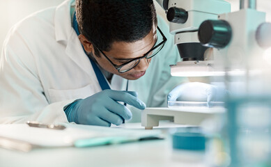 Wall Mural - scientific knowledge allows us to progress through the world. shot of a young scientist using a micr