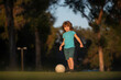 © Volodymyr - Little kid boy playing football in the field with soccer ball. Concept of children sport. Child playing football on the playground in park.