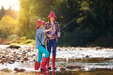 We Got One. Shot Of Two Young Girls Fishing By A River.