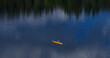 yellow boat with fisherman reflection of boat in water