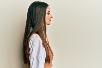 Wall Mural - Beautiful brunette young woman wearing casual clothes looking to side, relax profile pose with natural face with confident smile.