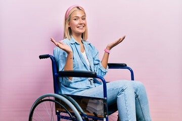 Poster - Beautiful blonde woman sitting on wheelchair smiling showing both hands open palms, presenting and advertising comparison and balance