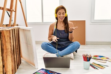 Young hispanic artist woman smiling happy drawing at art studio.