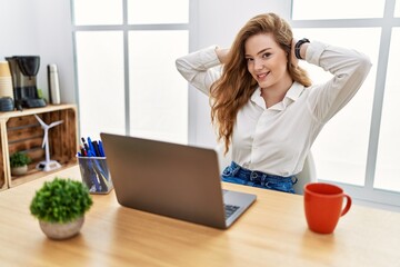 Sticker - Young caucasian woman working at the office using computer laptop relaxing and stretching, arms and hands behind head and neck smiling happy