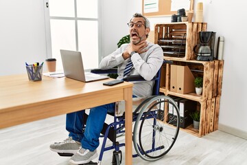 Wall Mural - Middle age hispanic man working at the office sitting on wheelchair shouting and suffocate because painful strangle. health problem. asphyxiate and suicide concept.