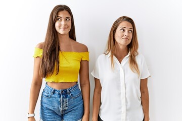 Canvas Print - Mother and daughter together standing together over isolated background smiling looking to the side and staring away thinking.