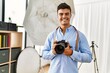 © Krakenimages.com - Young hispanic man photographer using professional camera at photography studio