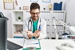 © Krakenimages.com - Young man with beard wearing doctor uniform and stethoscope at the clinic smiling with hands palms together receiving or giving gesture. hold and protection