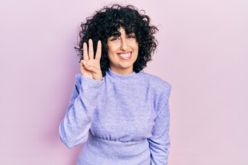 Poster - Young middle east woman wearing casual clothes showing and pointing up with fingers number three while smiling confident and happy.