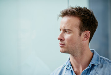 Poster - Focused on the future. Shot of a handsome young man looking thoughtful in a casual work environment.