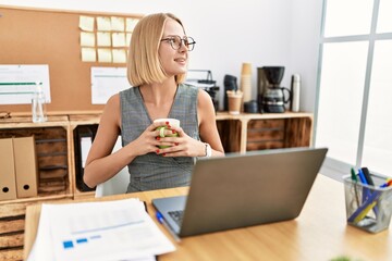 Poster - Young blonde woman drinking coffee working at office