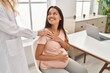 © Krakenimages.com - Young latin woman pregnant and doctor together at clinic